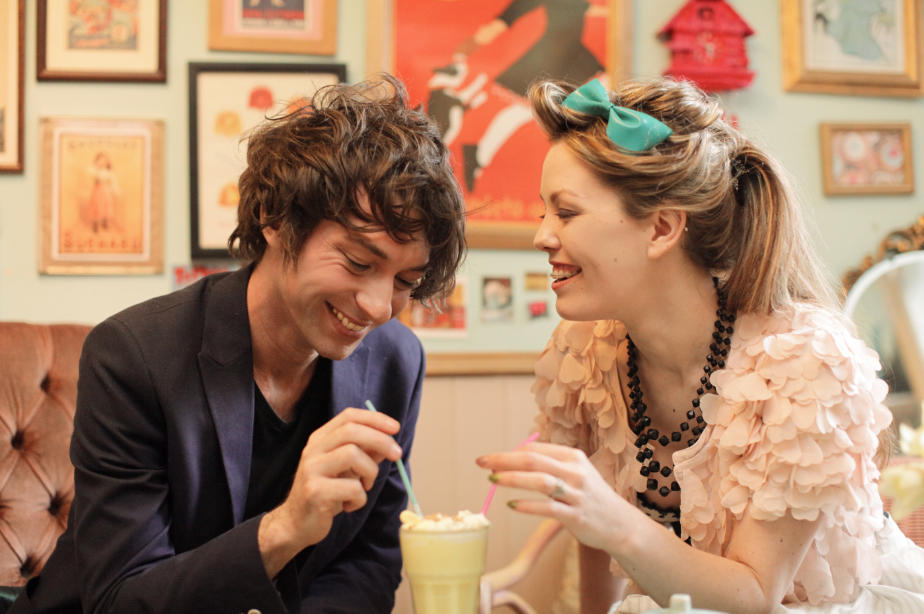 A beautiful couple on their engagement shoot sharing a milkshake with burlesque fashion, in Cocoa Wonderland, Sheffield