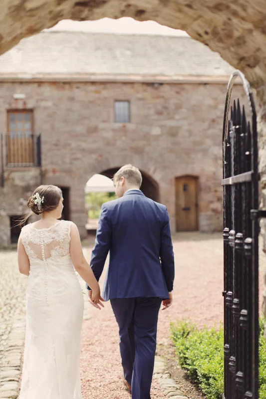 Bride and groom holding hands at Blencowe Hall, The Rowley Estates, Lake District wedding