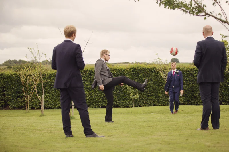 Wedding guests playing football at Blencowe Hall, The Rowley Estates, Lake District wedding