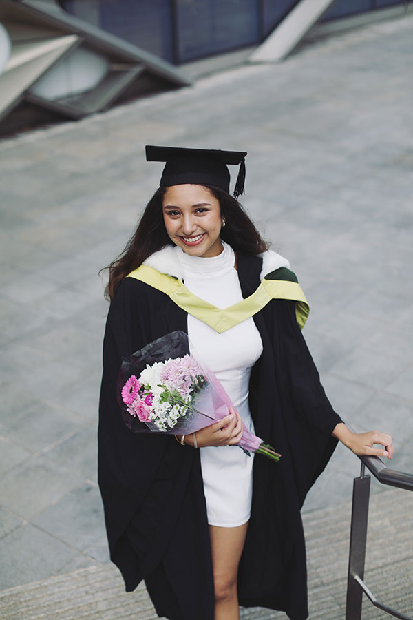 Photoshoots 2 Smiling Sheffield University graduate in black gown holding flowers
