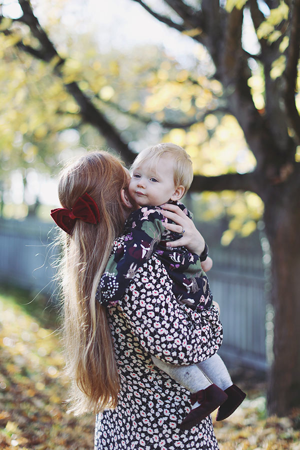 Mother holding one-year-old baby during outdoor first birthday photoshoot in Derbyshire