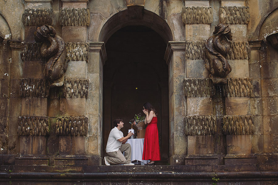 Couple sharing a romantic proposal moment in the gardens of Chatsworth House, Derbyshire