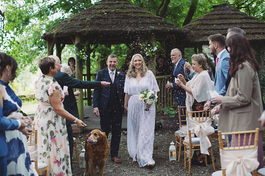 Bride and groom walking hand-in-hand through the gardens during their Biggin Hall Hotel wedding in the Peak District.