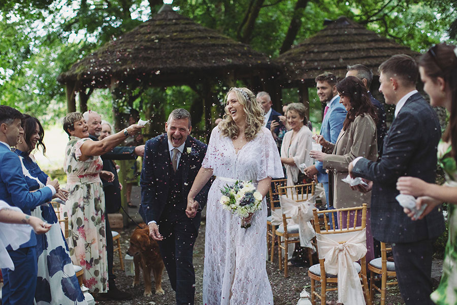 Bride and groom walking hand-in-hand through the gardens during their Biggin Hall Hotel wedding in the Peak District.