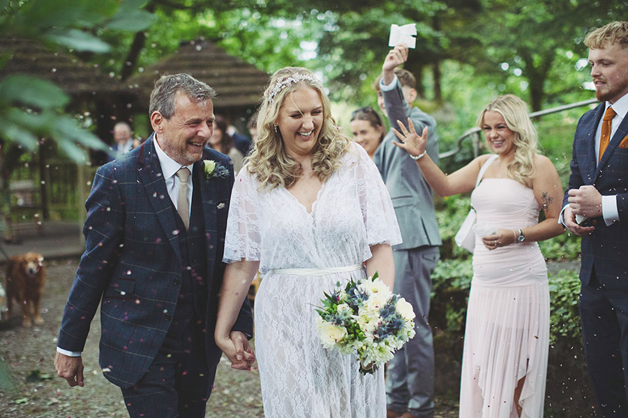 Bride and groom walking hand-in-hand through the gardens during their Biggin Hall Hotel wedding in the Peak District.