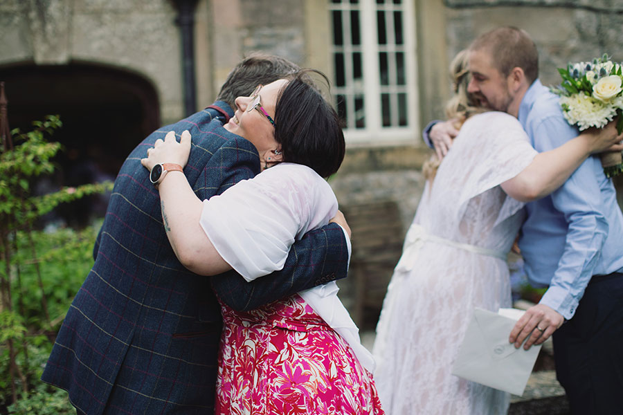Relaxed candid photo of the small wedding party enjoying the sunshine at Biggin Hall Hotel in the Peak District.