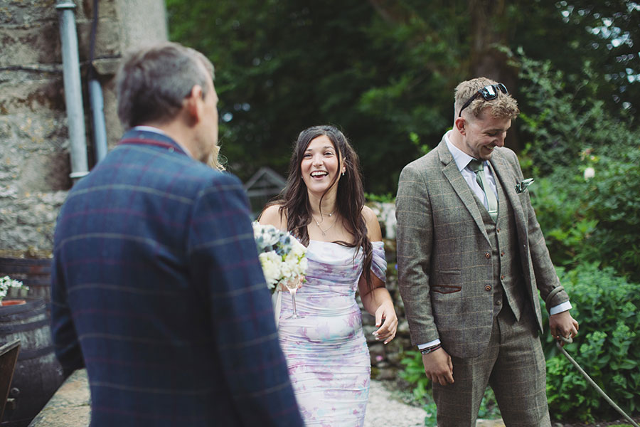 Relaxed candid photo of the small wedding party enjoying the sunshine at Biggin Hall Hotel in the Peak District.