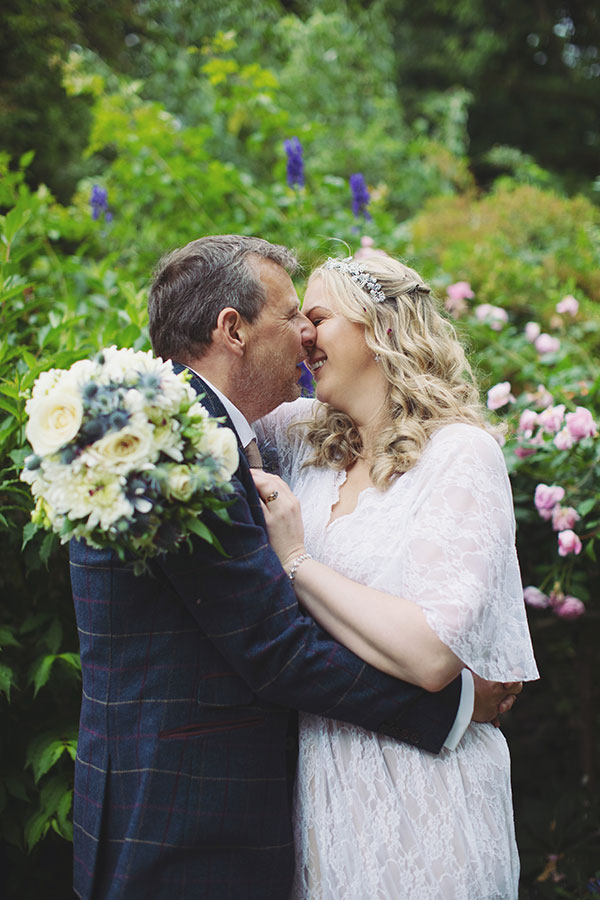 Wedding portrait of the bride and groom in front of the historic Biggin Hall Hotel building.