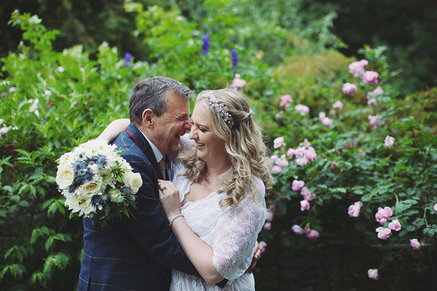 Bride and groom walking hand-in-hand through the gardens during their Biggin Hall Hotel wedding in the Peak District.