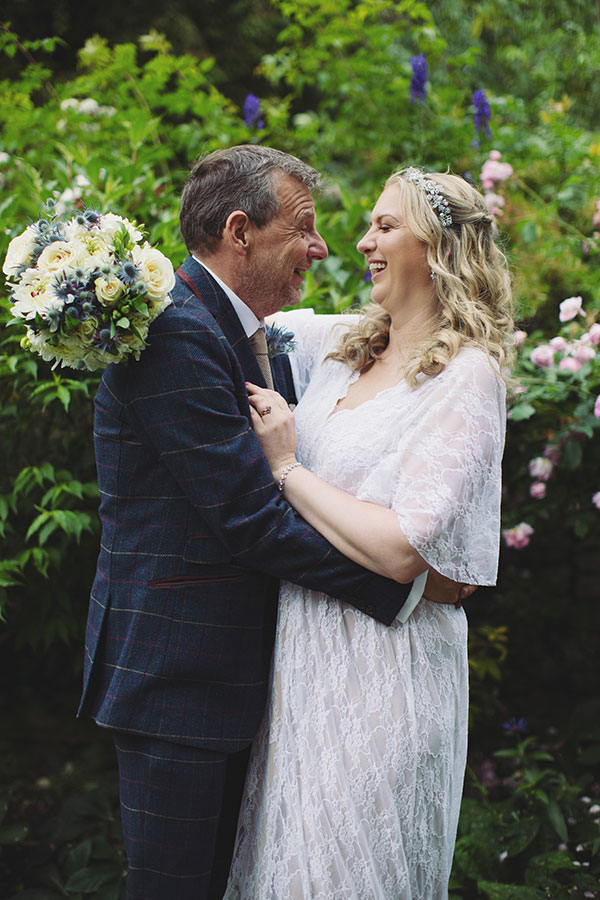Bride and groom walking hand-in-hand through the gardens during their Biggin Hall Hotel wedding in the Peak District.