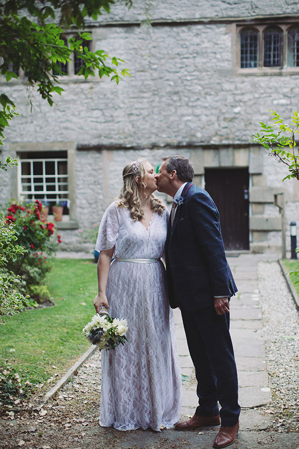 Wedding portrait of the bride and groom in front of the historic Biggin Hall Hotel building.