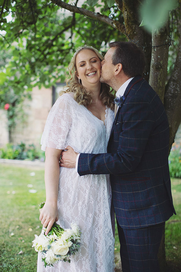 Wedding portrait of the bride and groom in front of the historic Biggin Hall Hotel building.