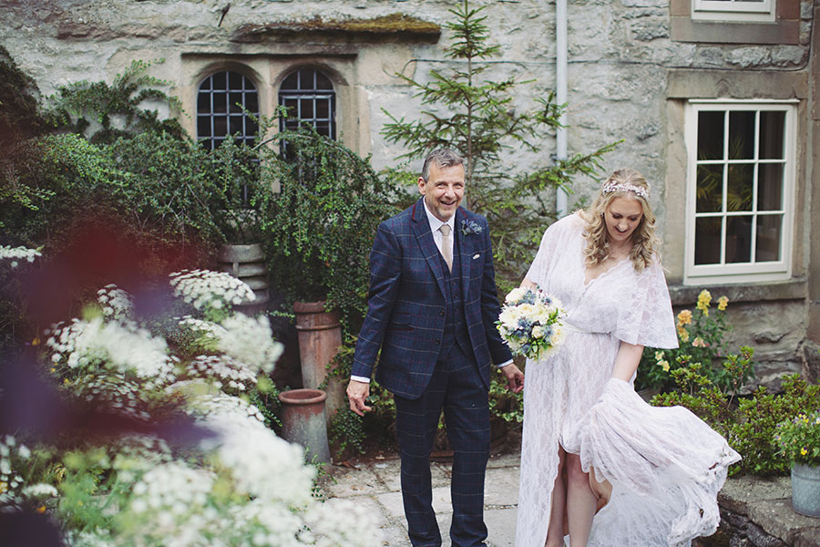 Wedding portrait of the bride and groom in front of the historic Biggin Hall Hotel building.