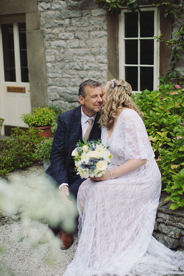 Wedding portrait of the bride and groom in front of the historic Biggin Hall Hotel building.