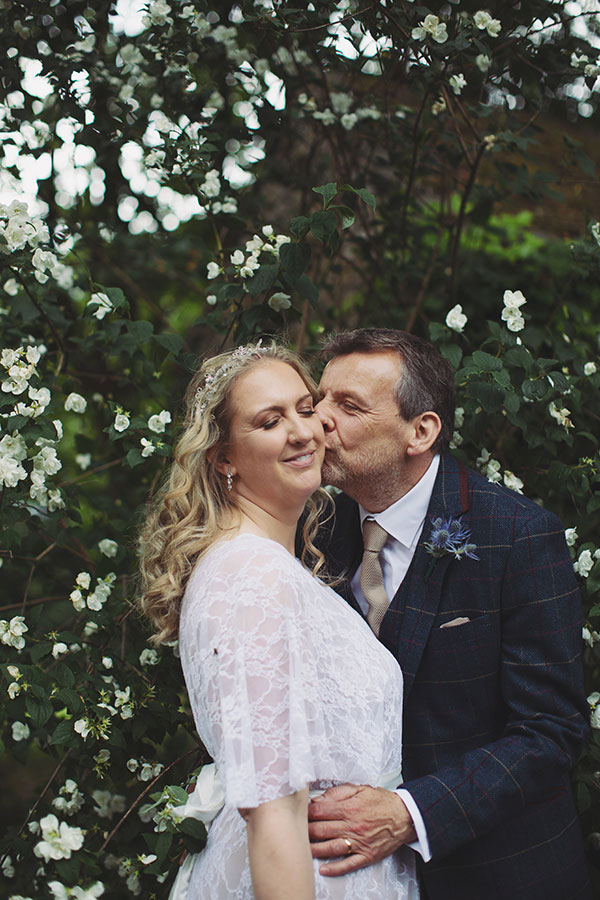 Wedding portrait of the bride and groom in front of the historic Biggin Hall Hotel building.