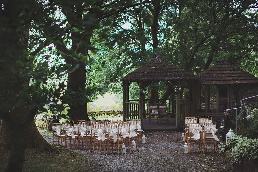 Sunny outdoor wedding ceremony at Biggin Hall Hotel with family and close friends gathered on the lawn.