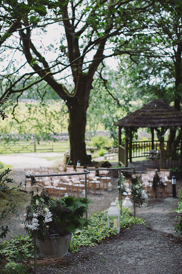 Sunny outdoor wedding ceremony at Biggin Hall Hotel with family and close friends gathered on the lawn.
