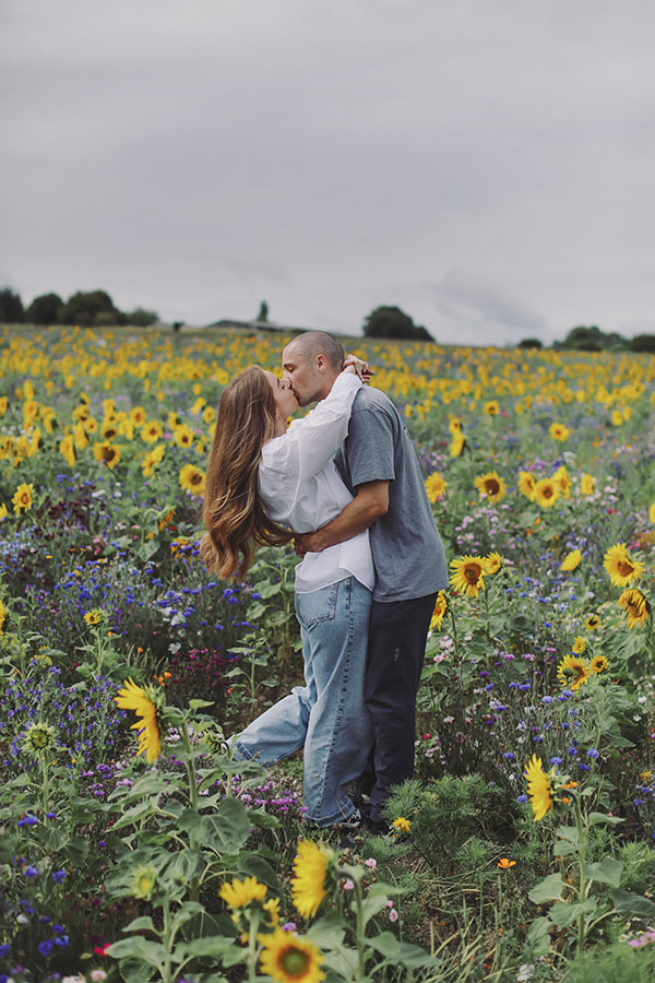 Ellie and Kamen laughing among sunflowers at Barlow Sunflower Field engagement photoshoot