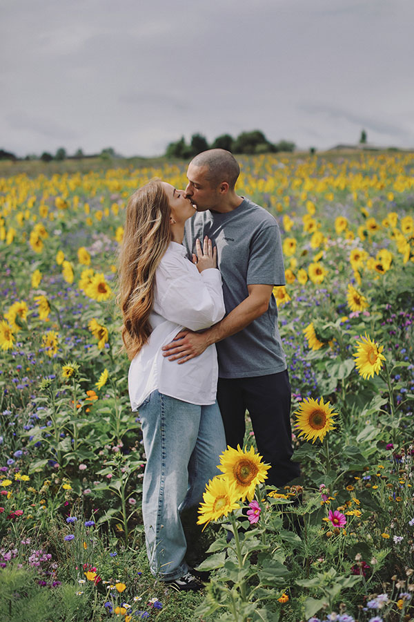 Couple walking through sunflowers at Barlow Sunflower Field engagement photoshoot