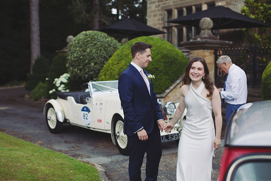 Bride and groom standing in the gardens during their Fisher’s Baslow Hall wedding — Derbyshire wedding photography.