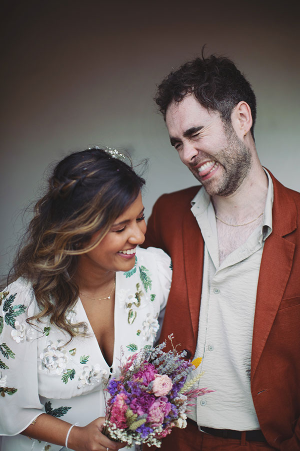 Bride wearing a floral wedding dress beside groom in an orange suit at a Kelham Island Museum wedding