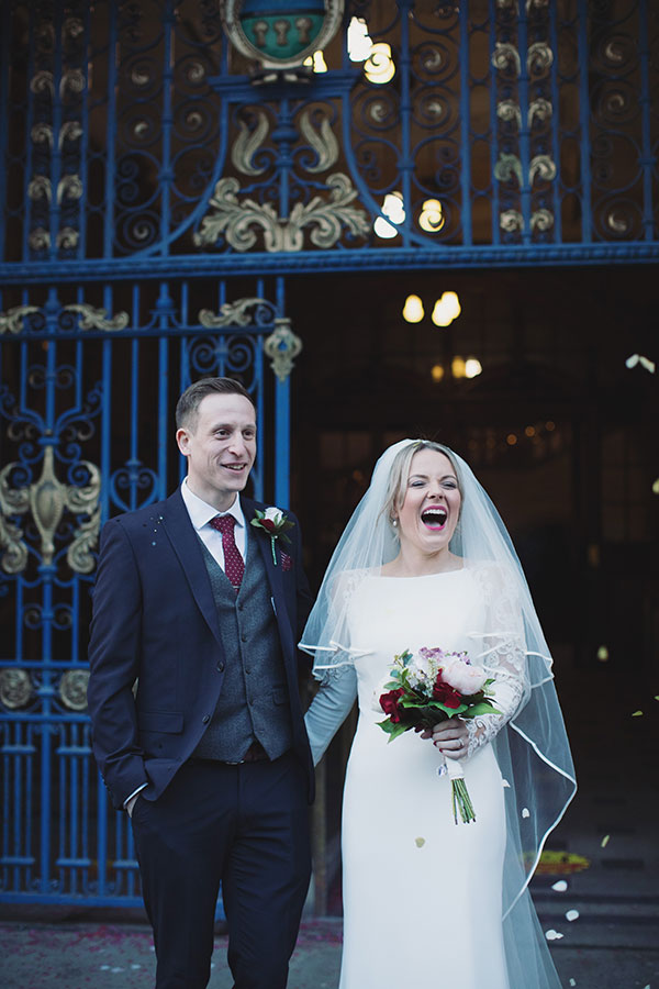 Bride and groom posing on the steps of Sheffield Town Hall after their wedding ceremony