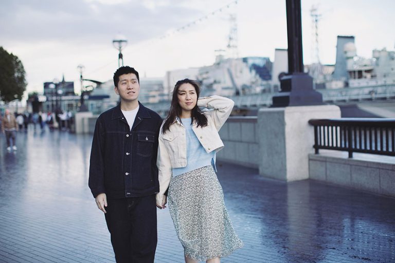 Couple laughing together during a London engagement photoshoot near the River Thames.