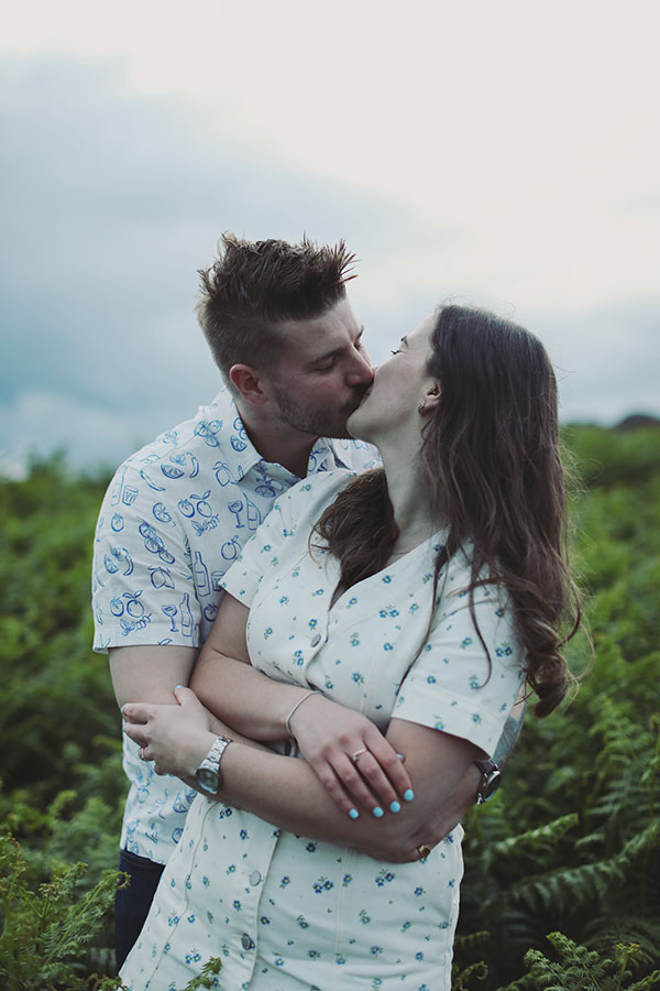 Diana & Alex ♡ Peak District Engagement Photoshoot 20 Couple standing among ferns in the Peak District, sharing a quiet moment during their engagement shoot.