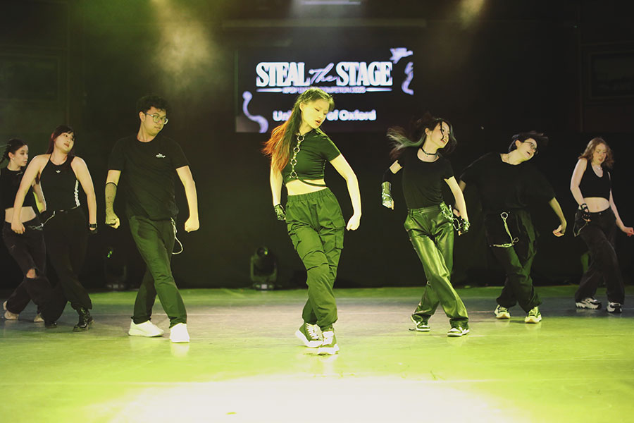UK Kpop Dance Competition ♡ Steal The Stage 2025 113 University K-pop society members in coordinated outfits performing sharp formation changes on stage.