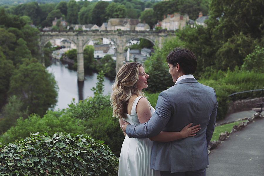 Couple embracing by the riverside in Knaresborough during their engagement session.