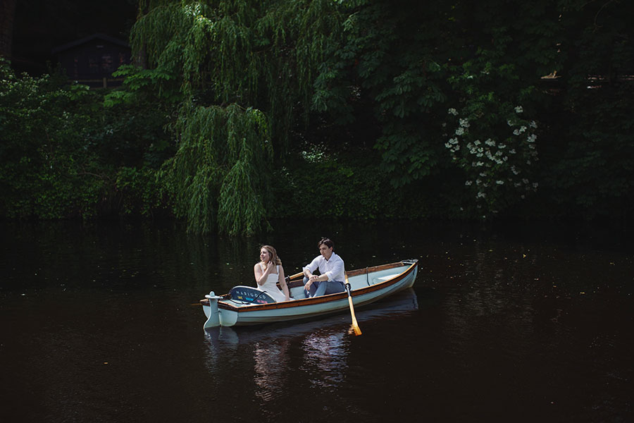 Couple rowing a boat on the River Nidd during a sunny Knaresborough engagement photoshoot.
