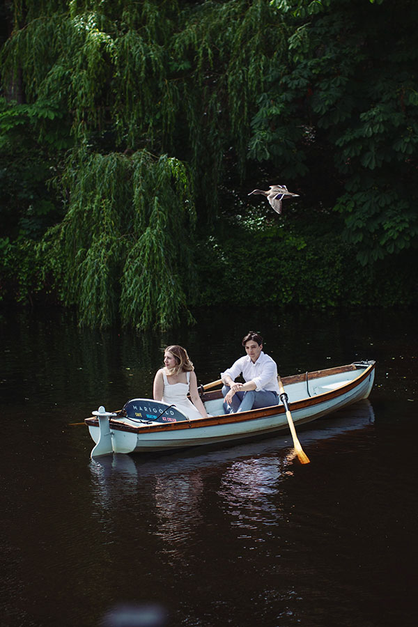 Couple rowing a boat on the River Nidd during a sunny Knaresborough engagement photoshoot.