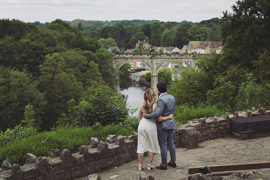 Couple embracing by the riverside in Knaresborough during their engagement session.