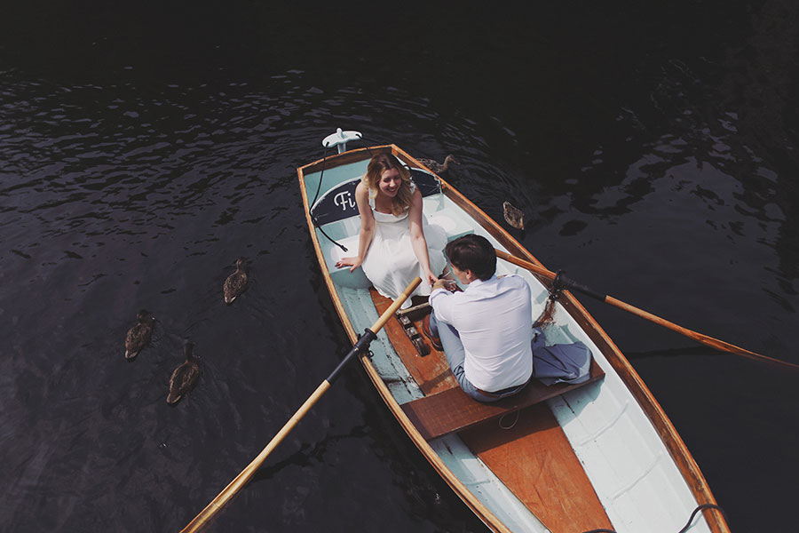 Couple rowing a boat on the River Nidd during a sunny Knaresborough engagement photoshoot.