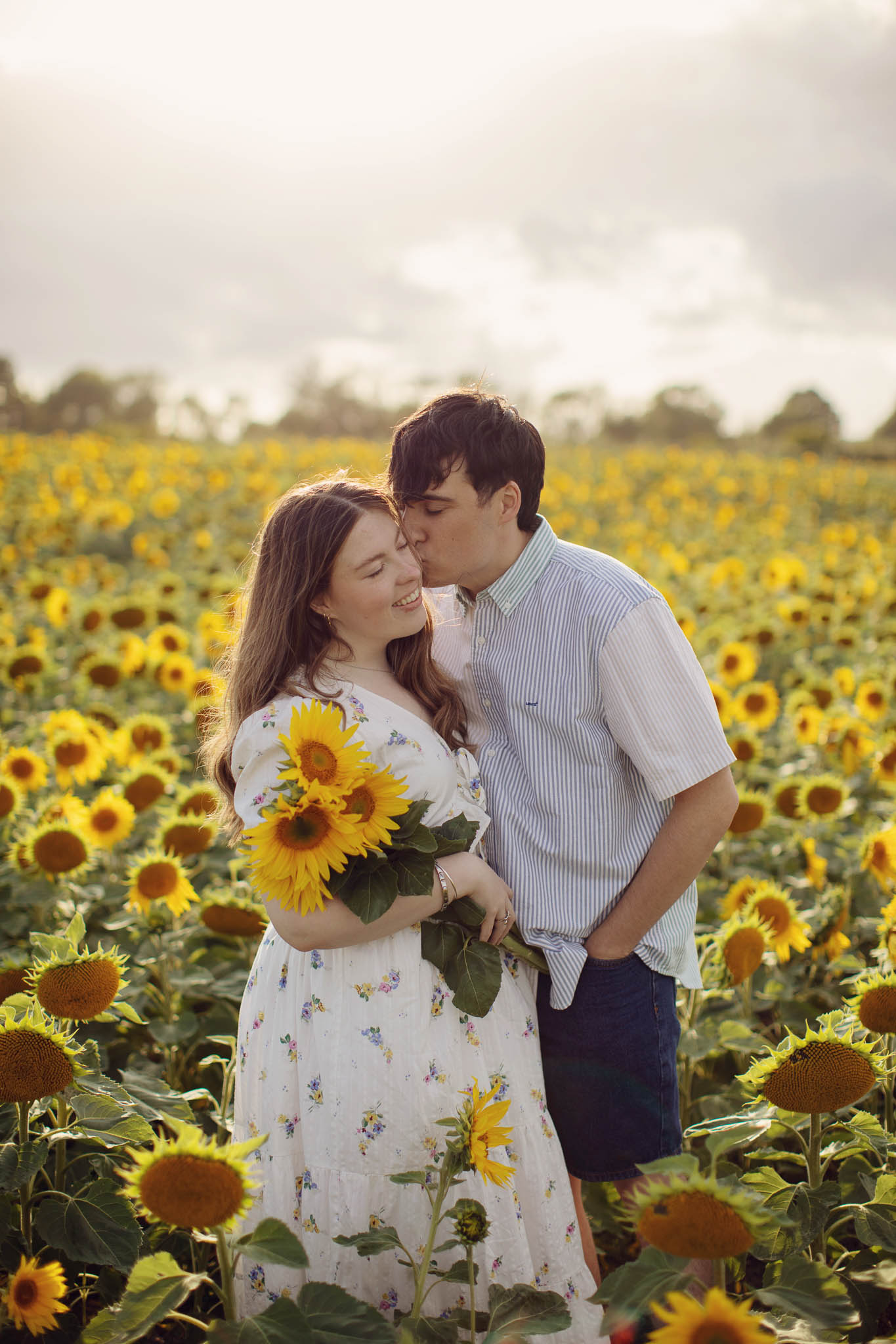 Natural portrait in sunflower field with soft evening light