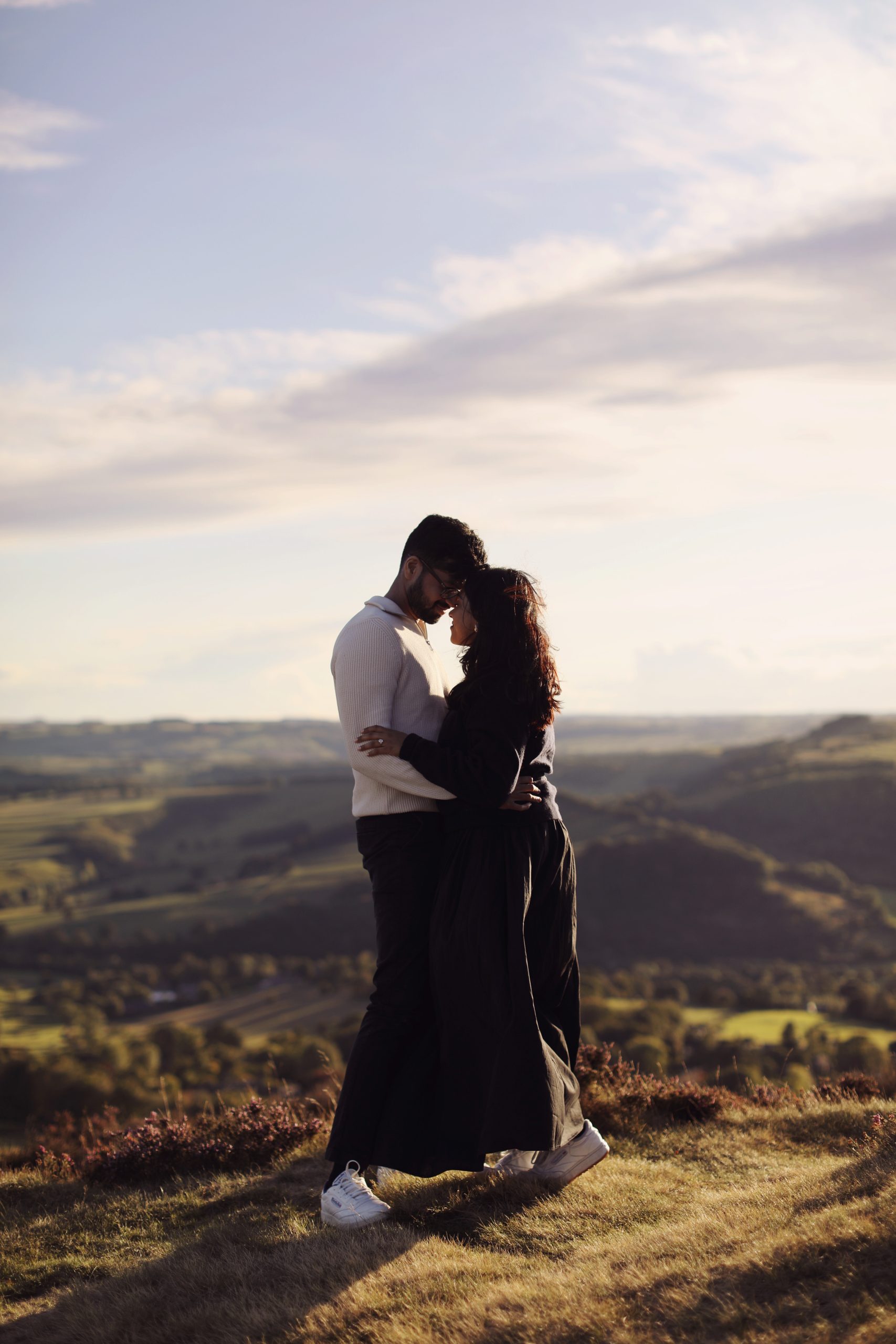Peak District Proposal Photographer ♡ Rahul & Rhea’s Surprise Proposal at Curbar Edge 12 Couple standing together on Curbar Edge with views across the Peak District.