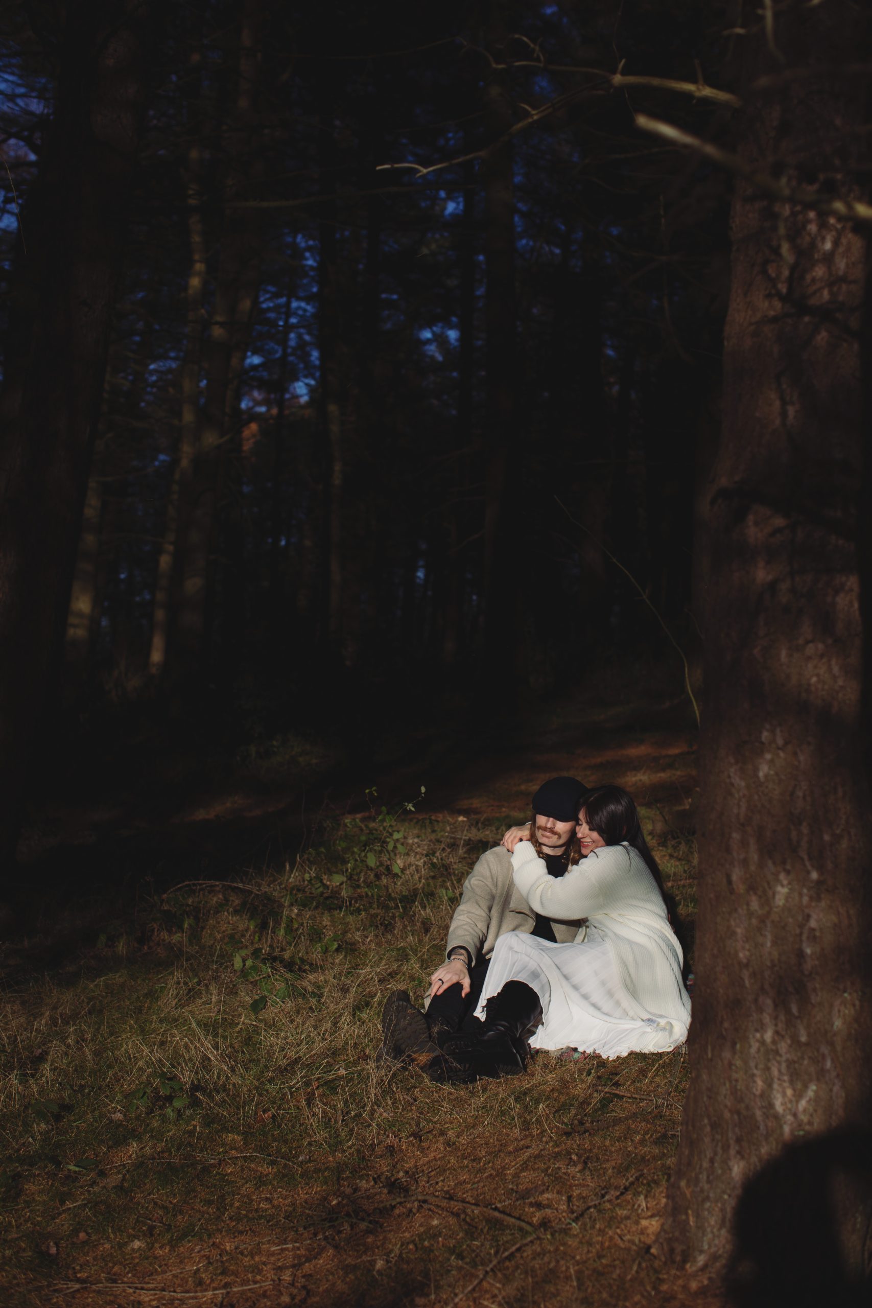 Cat & Liam ♡ Engagement Photoshoot at Shillito Woods 18 Cat and Liam embracing beneath tall trees during their outdoor engagement session at Shillito Woods.