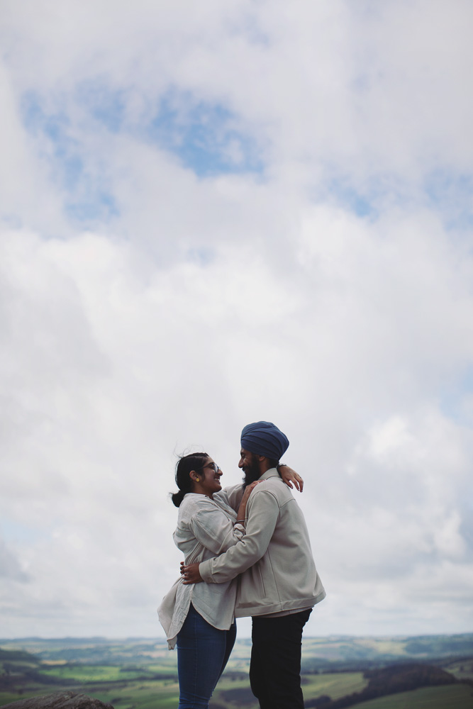 Wide view of a surprise proposal on a rocky Peak District viewpoint