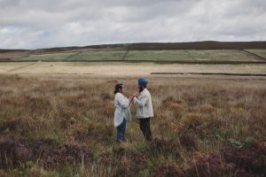 Harnaik & Mansukh ♡ Peak District Proposal Photoshoot 1 Couple holding hands during their Peak District proposal photoshoot with views across the countryside