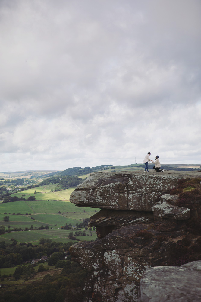 Newly engaged couple smiling and holding hands during a romantic Peak District photoshoot