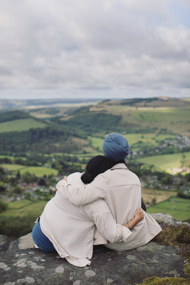Newly engaged couple smiling and hugging during a romantic Peak District photoshoot